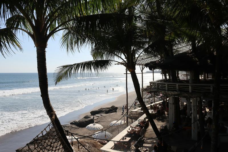 Palms and a beach bar above the surf on Bali's west coast