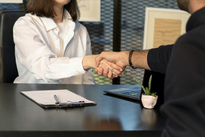 Poignée de main au-dessus d'un bureau après la signature d'un contrat d'assurance